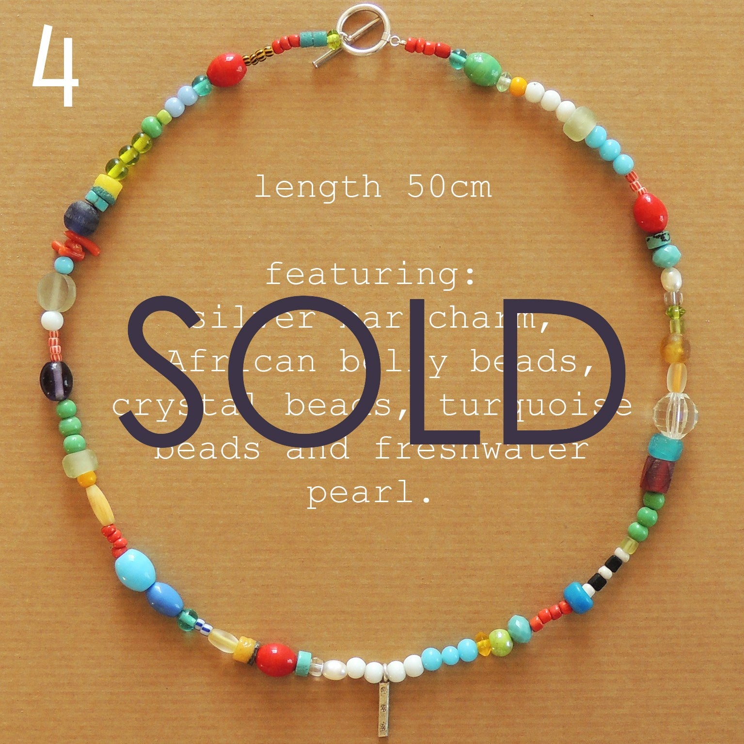 beaded necklace featuring a silver bar charm.